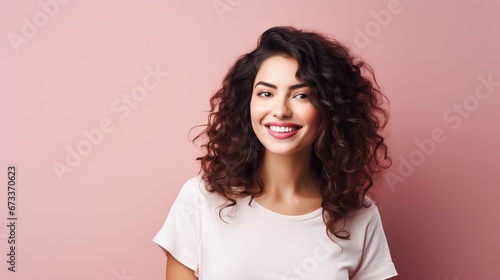 Portrait of a cheerful young woman wearing pink shirt standing isolated over pink background