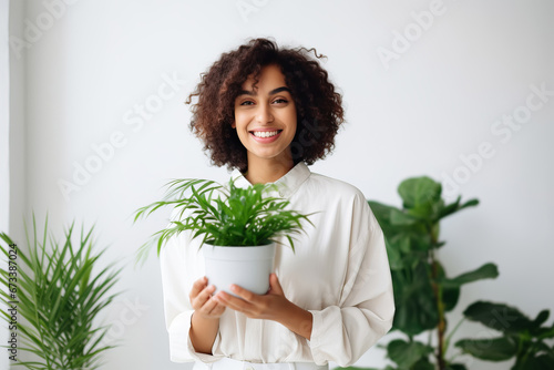 Woman taking care about houseplant and holding pot of houseplant. Home gardening, Plant care