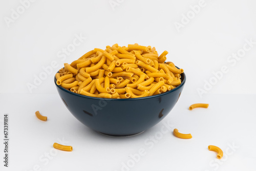 pasta horns in a deep blue bowl on a white background
