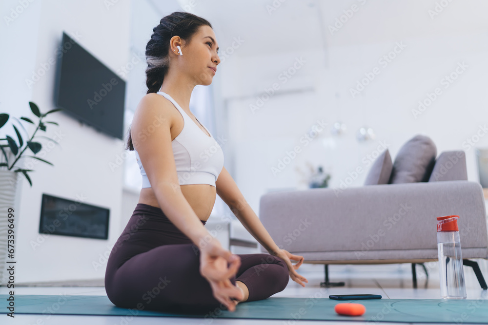 Woman meditating in lotus pose at home Woman meditating in lotus pose at home