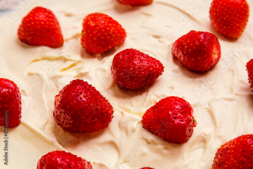 Fresh juicy red strawberries in whipped cream close-up. Horizontal