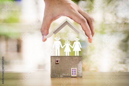 Investor hand hold to open a roof and a coin stack substantial savings money inside the house and paper cut family put on the top, Business investment or loan for real estate concept.