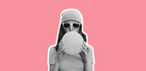 Fashionable portrait of stylish cool young woman inflating chewing gum wearing pink hat on pink studio background
