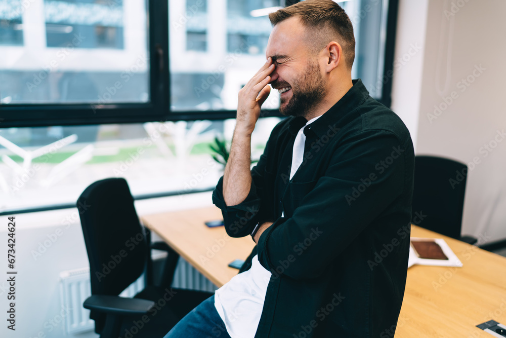 Smiling man leaning on table in meeting room in office Smiling man leaning on table in meeting room in office