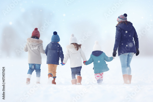 A young camp counselor plays with a diverse and multiracial group of children in a snowy natural setting during the Christmas holidays at a winter camp.