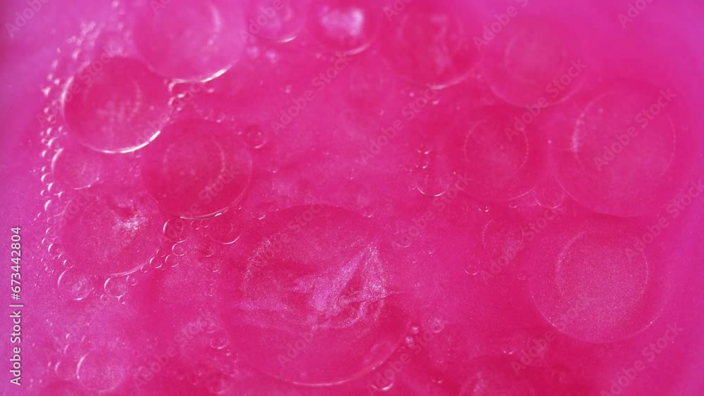 Abstract background. Bubbles liquid. Oily surface. Transparent drop circles moving spreading in neon pink shimmering glitter water in creative captivating art. Abstract background. Bubbles liquid. Oily surface. Transparent drop circles moving spreading in neon pink shimmering glitter water in creative captivating art.