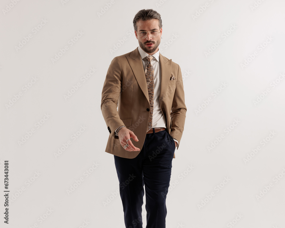 Fototapeta premium cool fashion man with glasses walking with hands in pockets