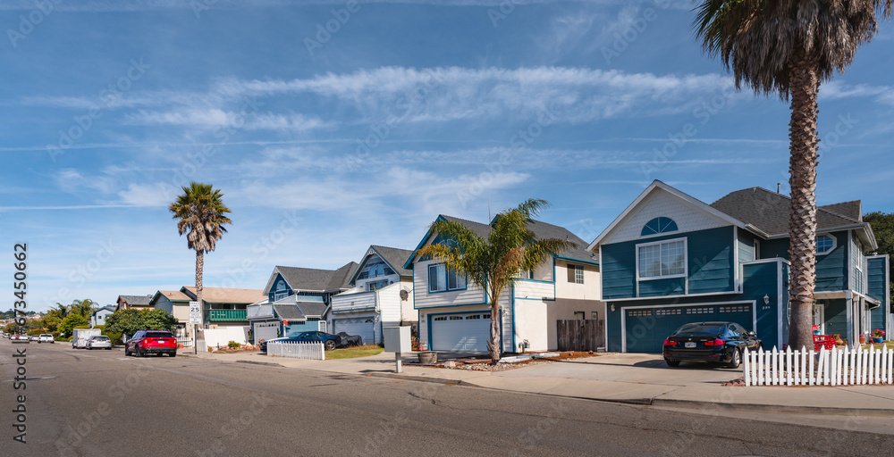 A picturesque row of colorful houses lining a charming, tree-lined street - obrazy, fototapety, plakaty 