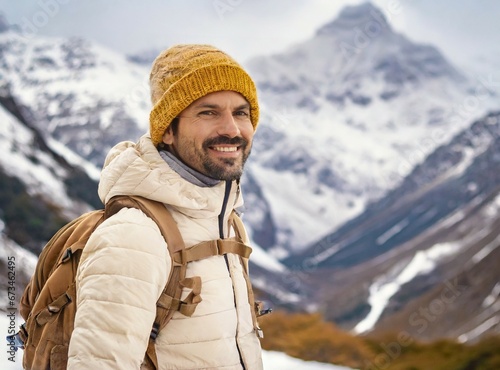 Caucasian man smiling while hiking snowy mountains on winter vacation