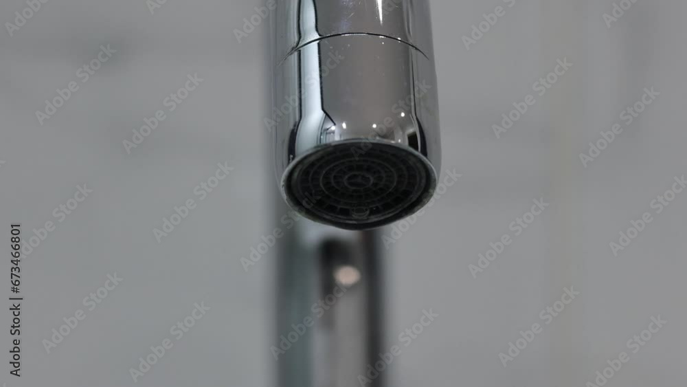 Extreme close-up of a metal water faucet on a white background isolated. Extreme close-up of a metal water faucet on a white background isolated.