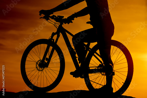 Silhouetted Cyclist Embracing the Sunset. A silhouette of a person riding a bike at sunset