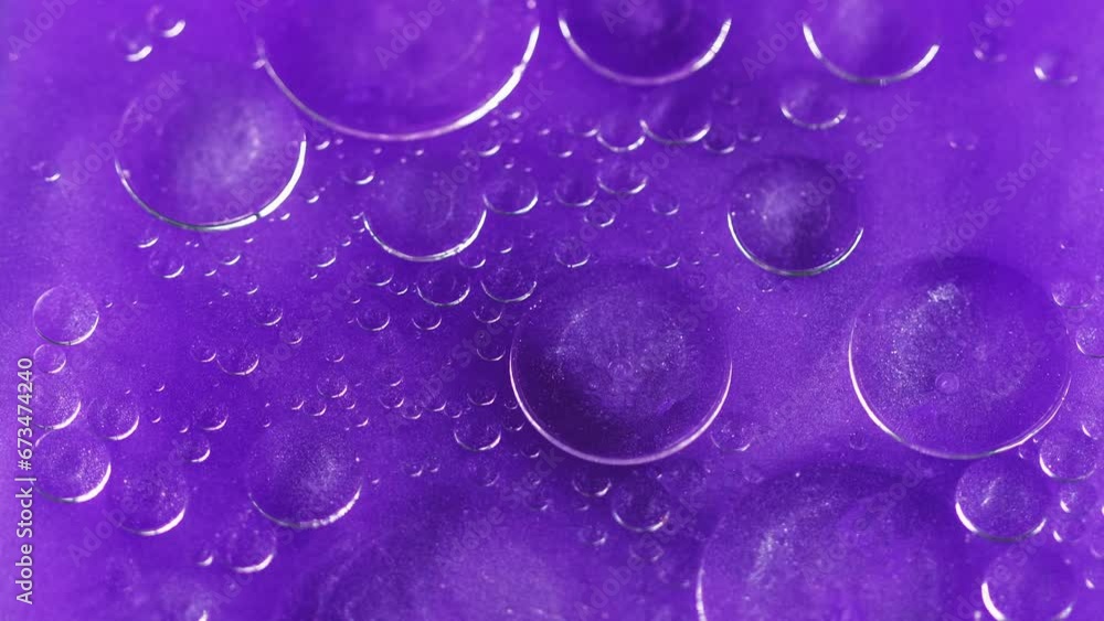 Abstract background. Bubbles liquid. Oily surface. Transparent drop circles moving spreading in neon violet shimmering glitter water in creative captivating art. Abstract background. Bubbles liquid. Oily surface. Transparent drop circles moving spreading in neon violet shimmering glitter water in creative captivating art.