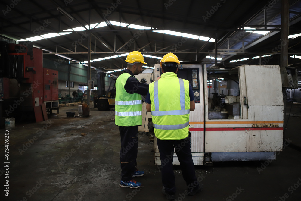 worker or engineer working in factory with safety uniform , safety hat and safety glasses , image is safety concept or happy workplace worker or engineer working in factory with safety uniform , safety hat and safety glasses , image is safety concept or happy workplace