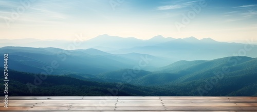 In the misty morning landscape you can admire a wooden table against the backdrop of a blurred mountain view The cool sensation in blue hues adds to the overall ambiance #673494482