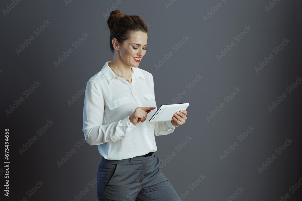 happy trendy business woman using applicationst PC against gray happy trendy business woman using applicationst PC against gray