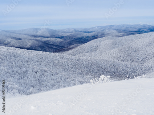 Fototapeta Naklejka Na Ścianę i Meble -  Winter mountain landscape. Mountain peaks covered with snow. View from Mala Rawka to Beskid Mounatin Range . Bieszczady Mountains. Poland