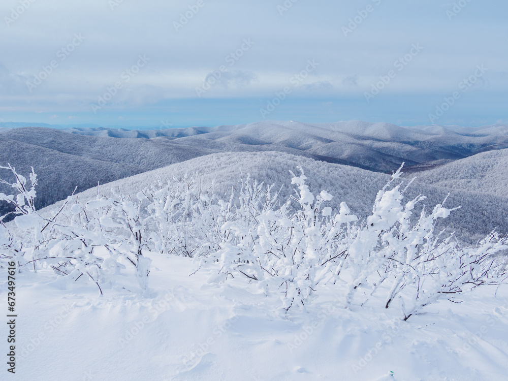Winter mountain landscape. Mountain peaks covered with snow. View from Mala Rawka to Beskid Mounatin Range . Bieszczady Mountains. Poland