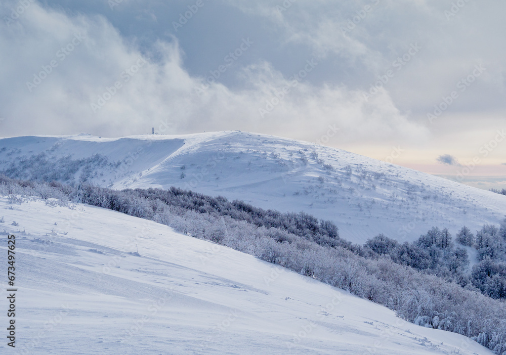 Winter mountain landscape. Snow-covered trees on mountain slopes. View from Mala Rawka to Wielka Rawka.  Bieszczady Mountains. Poland.
