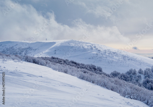 Winter mountain landscape. Snow-covered trees on mountain slopes. View from Mala Rawka to Wielka Rawka. Bieszczady Mountains. Poland.