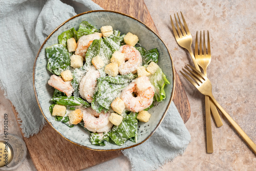 Fresh caesar salad on bowl with parmesan cheese and shrimps