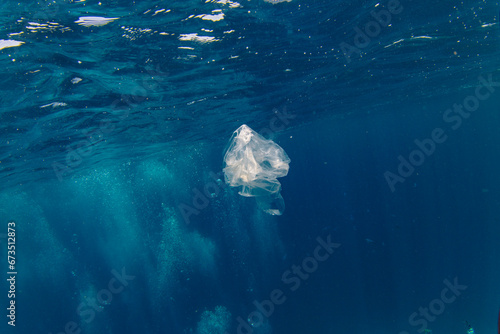 Plastic bag floating underwater on the blue depth, environmental pollution. Plastic pollution of Ocean © Lukas Gojda