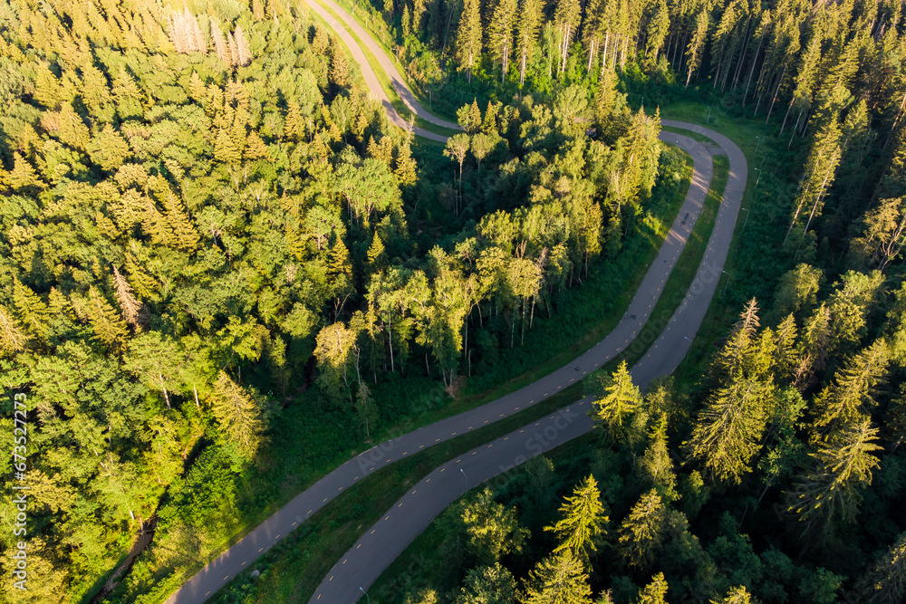 View from above of a roller ski track in the forest. Scenic asphalt road in forest area from the air