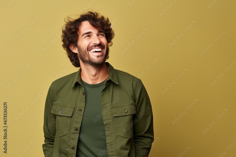 Portrait of a handsome man laughing and looking up over yellow background Portrait of a handsome man laughing and looking up over yellow background