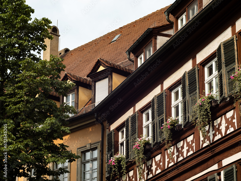 Half timbered building facade with beautiful flower pots. The houses are part of a historic old town in a German city. The ancient architecture is an attraction for tourists. Half timbered building facade with beautiful flower pots. The houses are part of a historic old town in a German city. The ancient architecture is an attraction for tourists.