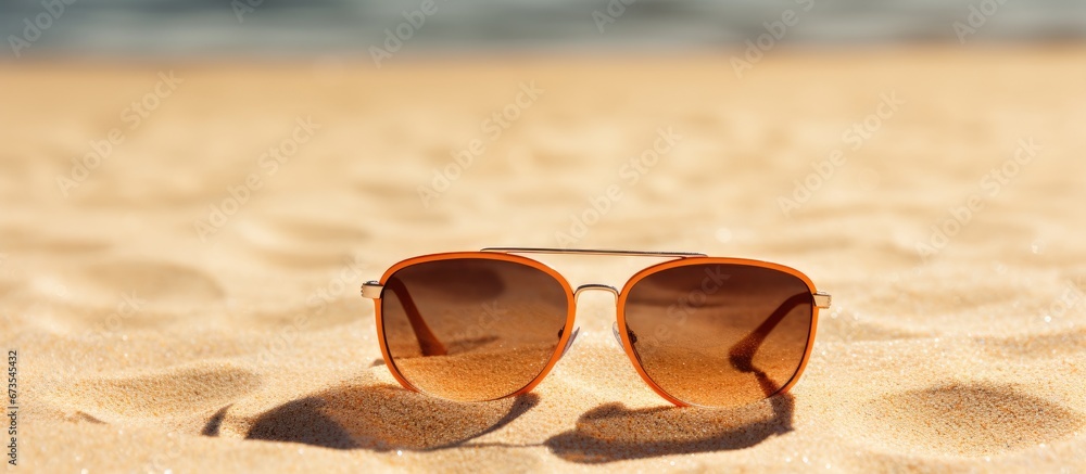 The idea of a peaceful vacation is represented by a sun sketch on the sandy shore and sunglasses