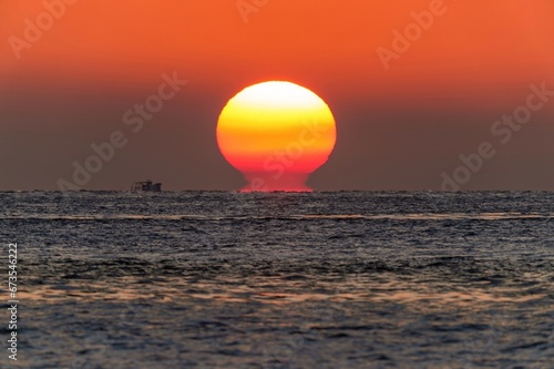 Fototapeta Naklejka Na Ścianę i Meble -  明石海峡で見た幻想的なダルマ夕日の情景