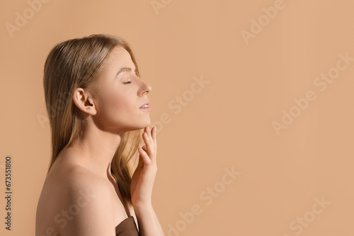 Beautiful young woman posing on beige background, space for text
