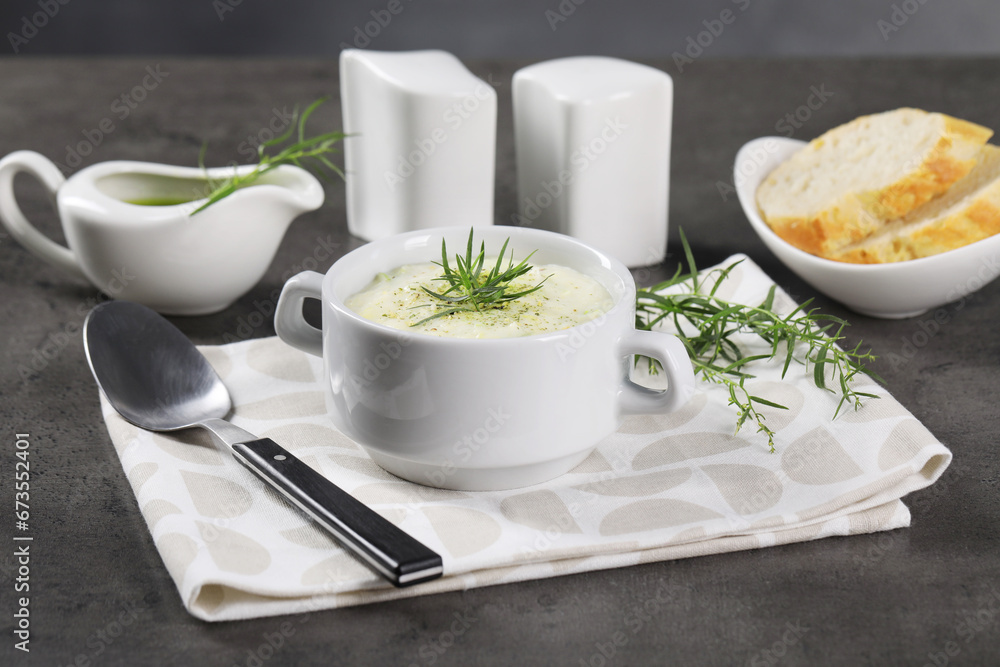 Delicious cream soup with tarragon, spices and potato in bowl served on dark textured table Delicious cream soup with tarragon, spices and potato in bowl served on dark textured table
