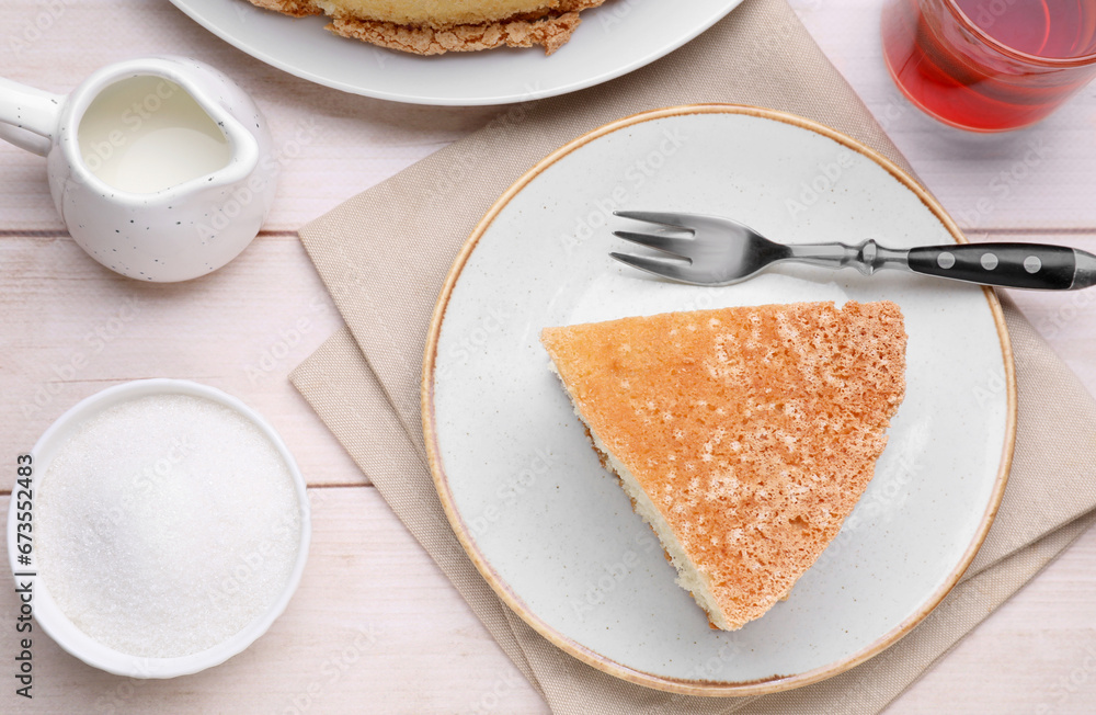 Piece of tasty sponge cake served on white wooden table, flat lay Piece of tasty sponge cake served on white wooden table, flat lay