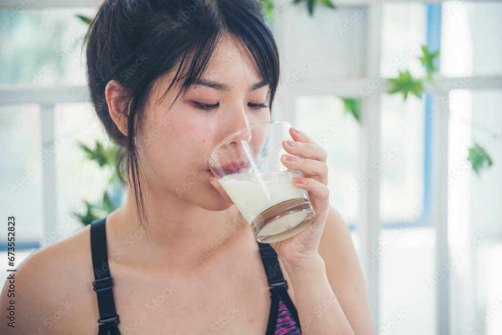 Women hands holding white glass of milk pouring from bottle. Asian women smile laugh look at camera health care home fitness lifestyle. Beautiful female drinking fresh milk low-fat dairy free lactose Women hands holding white glass of milk pouring from bottle. Asian women smile laugh look at camera health care home fitness lifestyle. Beautiful female drinking fresh milk low-fat dairy free lactose