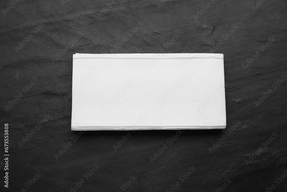 Stack of paper towels on black table, top view Stack of paper towels on black table, top view