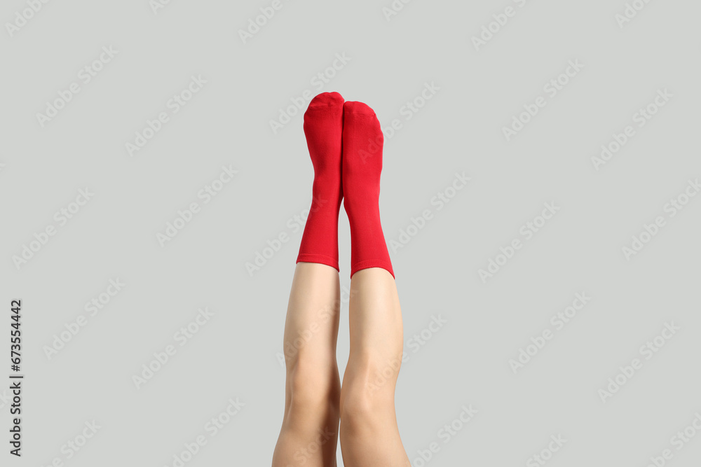 Woman in stylish red socks on light grey background, closeup Woman in stylish red socks on light grey background, closeup