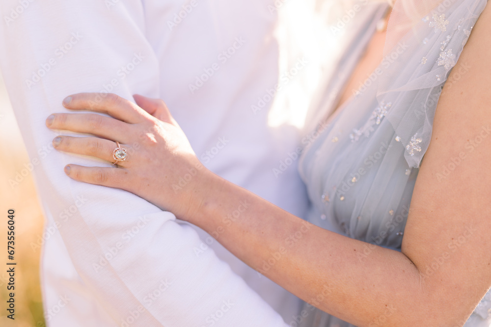 Woman's hand and fiancés arm during engagement session Woman's hand and fiancés arm during engagement session
