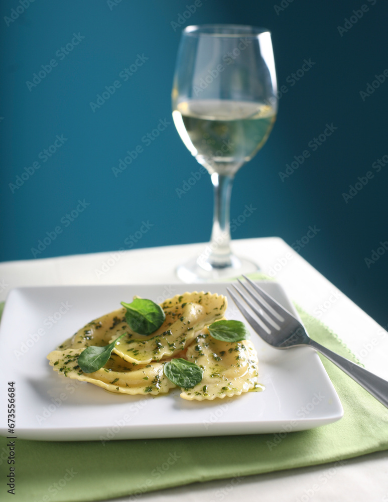 Italian ravioli stuffed with basil and served with a glass of white wine. Italian ravioli stuffed with basil and served with a glass of white wine.