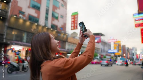 Young Asian tourists standing selfie taking a photo. Young woman beautiful tourists in Chinatown street food market, Bangkok, Thailand photo