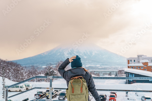 Woman tourist Visiting in Niseko, Traveler in Sweater sightseeing Yotei Mountain with Snow in winter season. landmark and popular for attractions in Hokkaido, Japan. Travel and Vacation concept photo