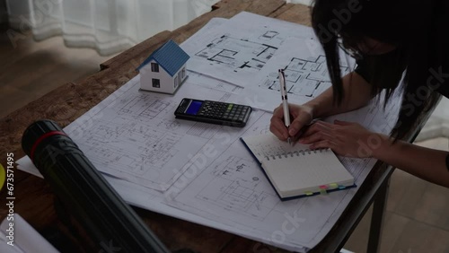 Engineer or architect working and calculations on paperworks blueprints construction drawings for structure for interior for houses and buildings. photo