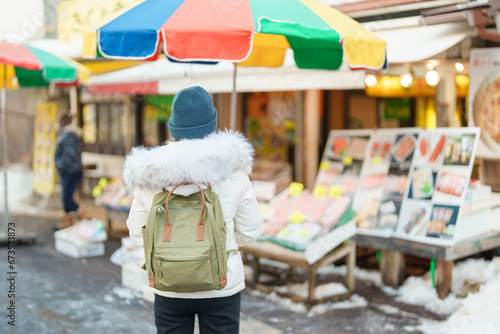 Woman tourist Visiting in Hakodate, Traveler in Sweater sightseeing Asaichi Morning Market Hakodate in winter. landmark and popular for attractions in Hokkaido, Japan. Travel and Vacation concept © Jo Panuwat D