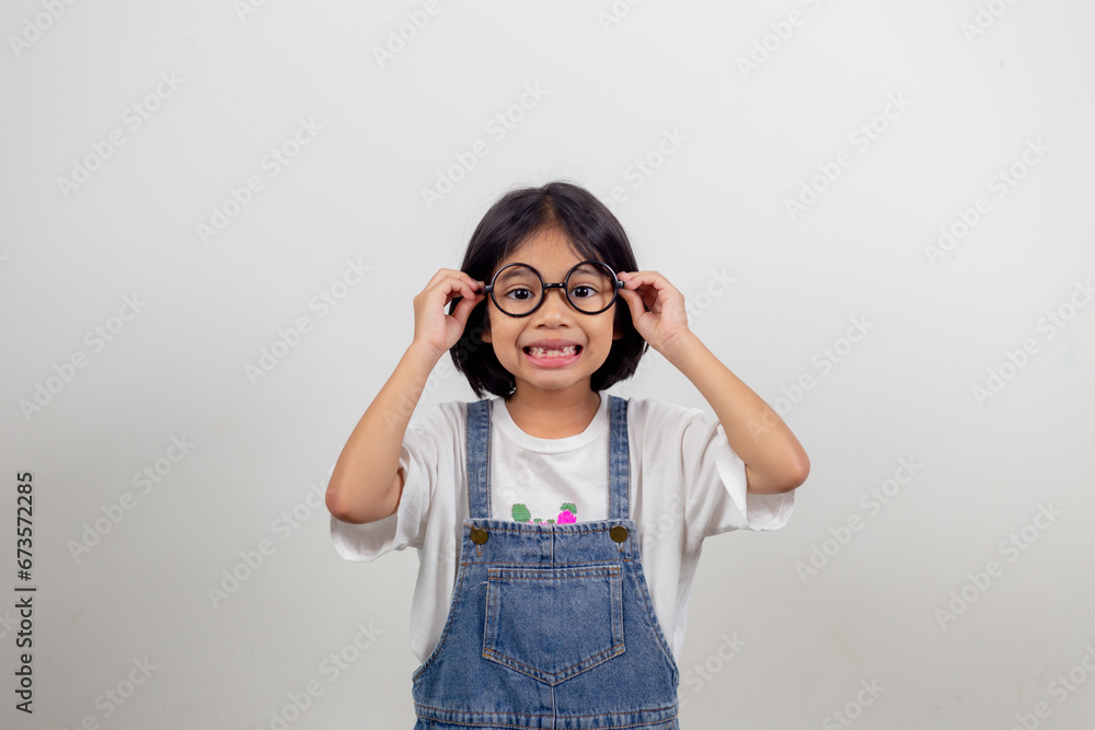 cute little preschooler girl isolated on grey studio background wear glasses look at camera, small child try spectacles at opticians, kid eyesight correction treatment concept cute little preschooler girl isolated on grey studio background wear glasses look at camera, small child try spectacles at opticians, kid eyesight correction treatment concept