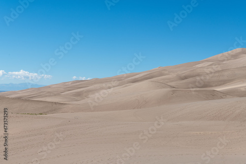 Gently sloping sand dunes under a bright blue sky at Great Sand Dunes National Park in southern Colorado