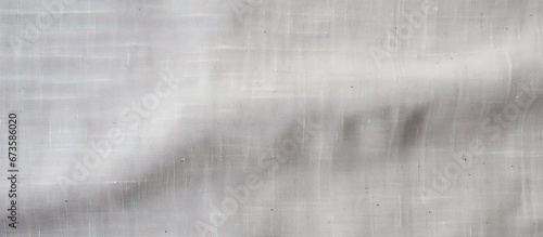 A canvas background with a natural linen texture in light gray suitable for designing purposes seen from a top view