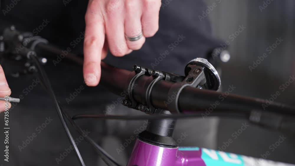 Process of fastening handlebar to bike stem, hand turning screws gently by bicycle mechanic. Closeup, detail Process of fastening handlebar to bike stem, hand turning screws gently by bicycle mechanic. Closeup, detail