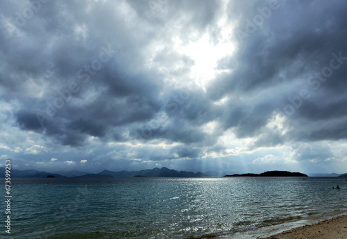 Philippines, Coron, sun rays breaking through clouds on the sea