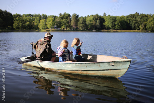 Little Girl Children Riding in Small Fishing Boat in Lake with their Dad