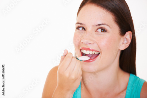Eating, yogurt and portrait of woman with healthy food, diet or nutrition in studio with happiness. Happy, face and girl with spoon, yoghurt and strawberry flavor of dairy, product or snack for lunch