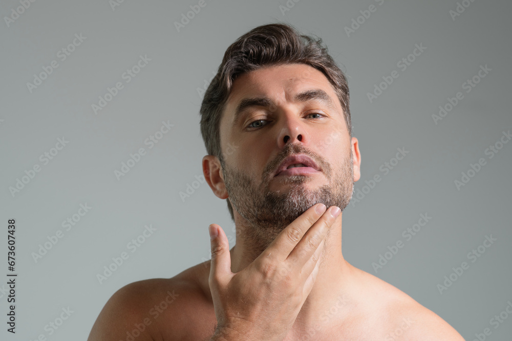 Obraz premium Male beauty. Cream treatment for male face. Beauty routine. Face of a beautiful man with perfect skin. Anti-aging and wrinkle cream. Concept of male beauty. Male skincare cosmetics concept. Skin care.